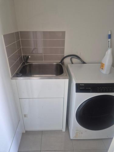 a kitchen with a sink and a washing machine at One Bedroom One Bathroom Unit With a New TV in Wulkuraka