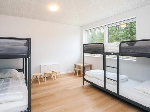 a room with three bunk beds and a window at Saltum Beach Luxury & Wellness in Saltum