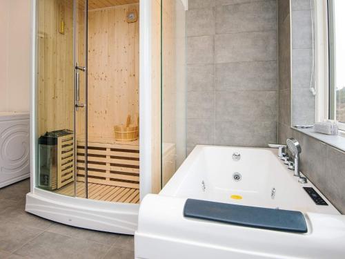 a bathroom with a white tub and a shower at Saltum Beach Luxury & Wellness in Saltum
