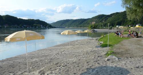 a group of tents on the shore of a river at Hotel-Restaurant Faustschlössl in Feldkirchen an der Donau