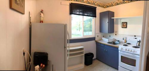 a small kitchen with a refrigerator and a window at Marland Motel in Powell River