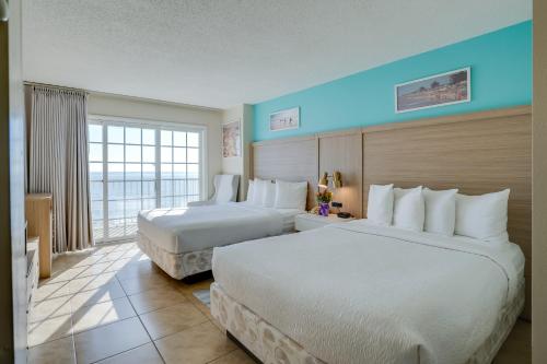 a hotel room with two beds and a window at Paradise Plaza Inn in Ocean City
