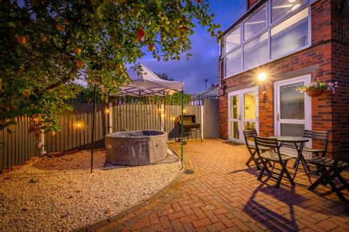 a patio with a fire pit and a table and chairs at Phenomenal Stay - Private Parking & Hot tub in Liversedge