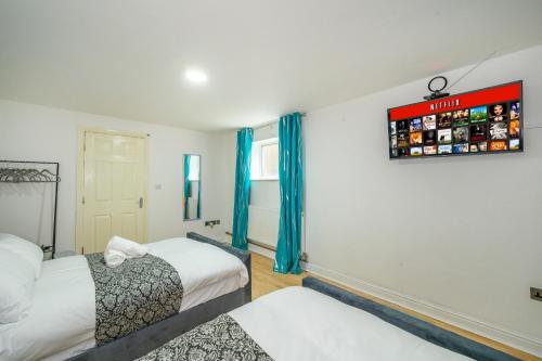 a bedroom with two beds and a sign on the wall at Phenomenal Stay - Private Parking & Hot tub in Liversedge