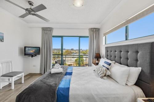 a bedroom with a large bed with a large window at Sunshine Towers Boutique Apartments in Maroochydore