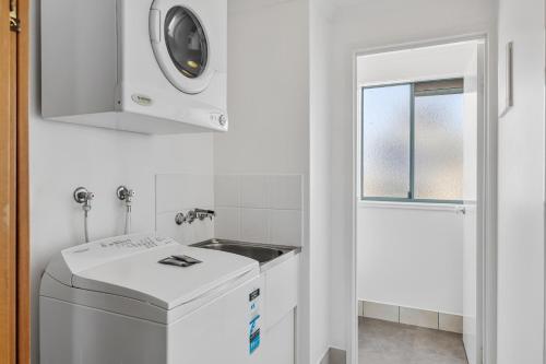 a laundry room with a washing machine and a window at Sunshine Towers Boutique Apartments in Maroochydore