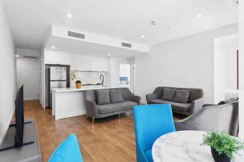 a kitchen and living room with two chairs and a table at The Cullinan Apartments by CLLIX in Adelaide