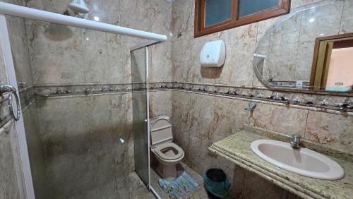 a bathroom with a toilet and a sink and a mirror at Almar Hospedagem 2 ARRAIAL DO CABO in Arraial do Cabo