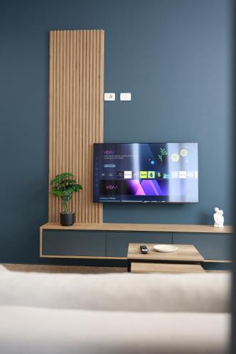 a living room with a tv and a table at Palm Vista Retreat in Durrës