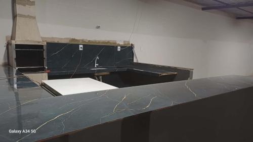 an empty room with a black counter top at Happy day chácaras in Uberlândia