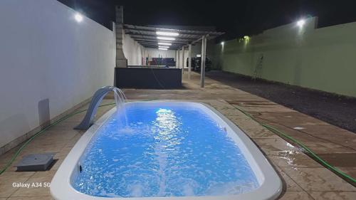 a hot tub in a building with blue water at Happy day chácaras in Uberlândia