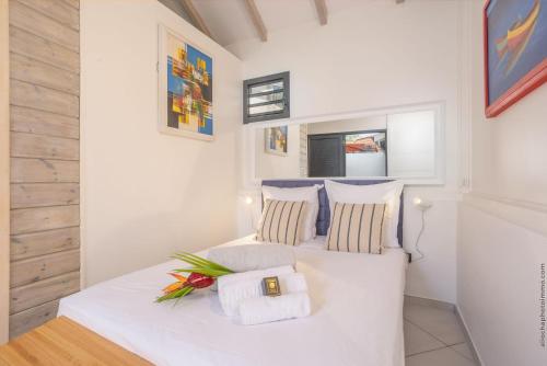 a bedroom with a white bed with towels on it at Bungalow PunchCoco - Beachfront in Les Trois-Îlets