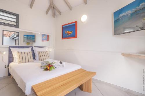a bedroom with a bed with a wooden bench at Bungalow PunchCoco - Beachfront in Les Trois-Îlets