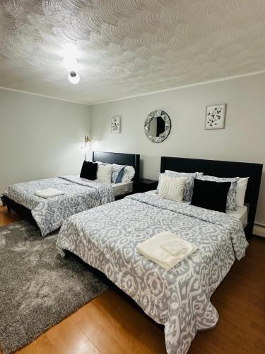 a bedroom with two beds and a ceiling at Cozy Private Apartment with 2 Queen size Beds in Moncton
