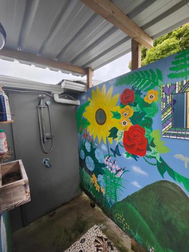 a rv with a painting of flowers on the wall at garden cabin in Waikino