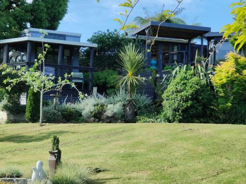 a house with a yard in front of a house at garden cabin in Waikino