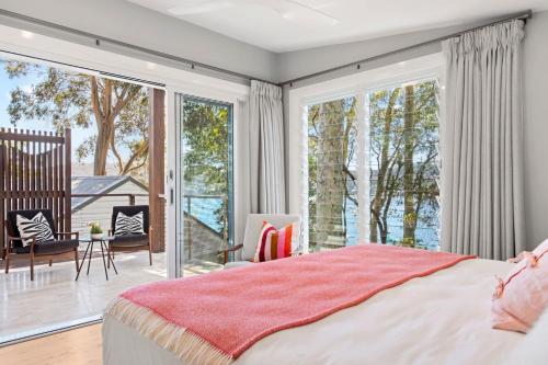 a bedroom with a bed and a large window at The Treehouse Avalon in Whale Beach