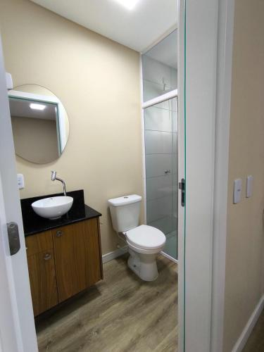 a bathroom with a toilet and a sink and a mirror at Studio no centro de Pomerode! in Pomerode