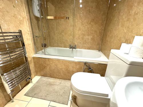 a bathroom with a tub and a toilet and a sink at meze in Perth