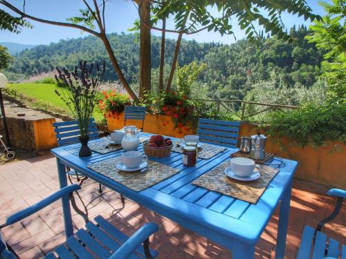 un tavolo blu con cibo sopra su un patio di Belvilla by OYO Podere Pulicciano Pozzo a Pian di Scò