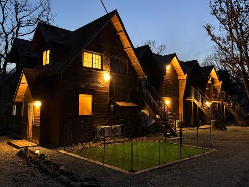 a house with lights on the front of it at 久住みんなの森ロッジ202号-Kuju Forest Retreat 最大4名 in Kokonoe