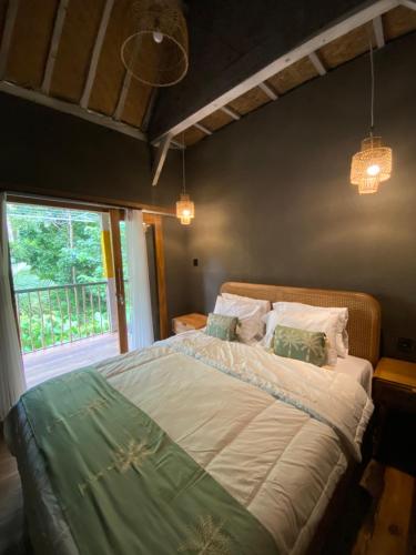 a bedroom with a large bed with a window at Seenau House Bali in Selemadeg