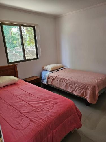 a bedroom with two beds and a window at Cabañas del cerro sombrero in Arica