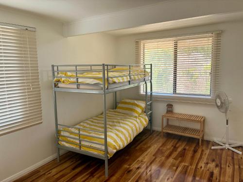two bunk beds in a room with wooden floors at Kite House in Guilderton