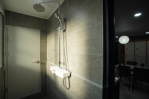 a bathroom with a shower with a sink and a table at NamSan203 Guest house in Seoul