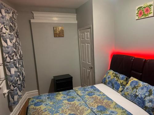 a bedroom with a bed with a red light at Grove#9 in Irvington