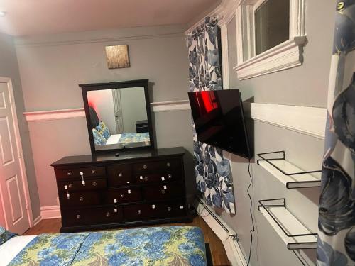 a bedroom with a dresser and a mirror at Grove#9 in Irvington