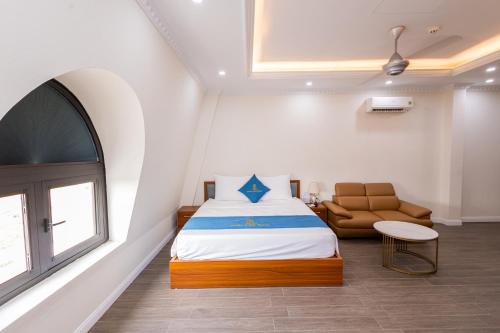a bedroom with a bed and a chair and a window at Royal Louis Hotel in Hanoi