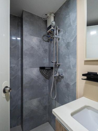 a bathroom with a shower and a sink at Mactan Cebu Cozy Relaxing Studio with Pool View Balcony in Pajak