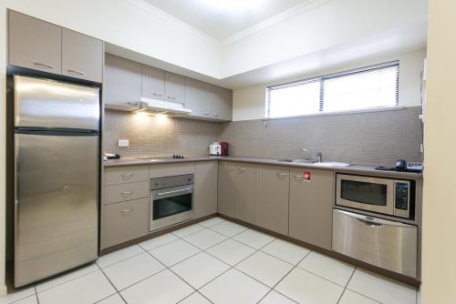 a kitchen with stainless steel appliances and a window at Southern Cross Atrium Apartments in Cairns