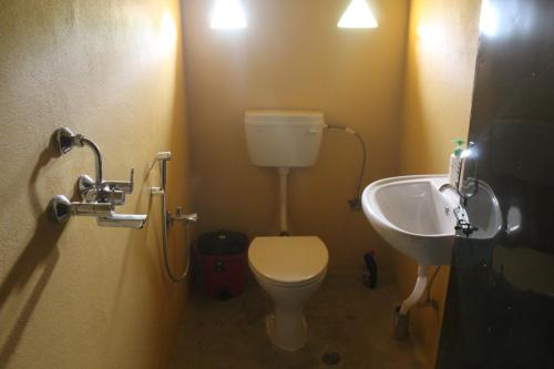 a small bathroom with a toilet and a sink at Shanta Ghar A Rustic Guesthouse in Chitwan