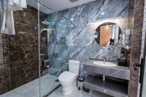 a bathroom with a toilet and a sink and a shower at Royal Louis Hotel in Hanoi