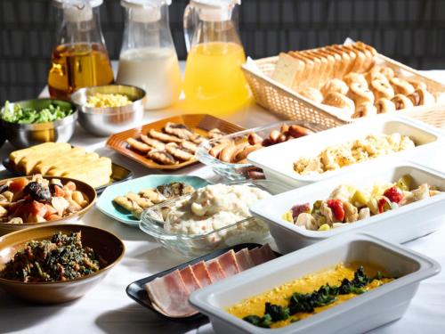 a table with many different dishes of food on it at Urbain Tokyo Ueno Kitasenju in Tokyo