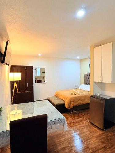 a bedroom with a bed and a table in it at Hospedaje La Gardenia in Zacatlán