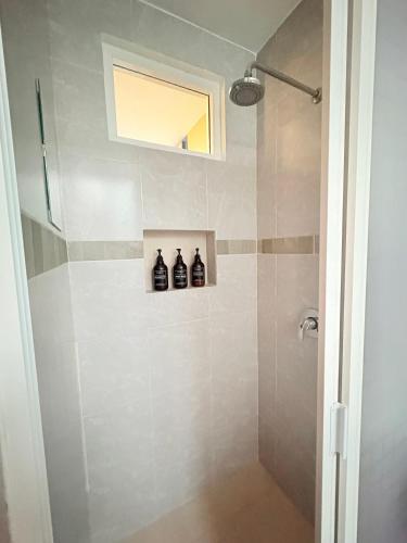 a bathroom with a shower with three bottles on a shelf at Hospedaje La Gardenia in Zacatlán
