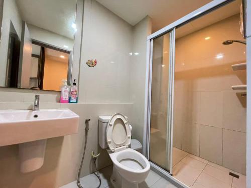 a bathroom with a toilet and a sink and a shower at The Base Central Pattaya by Adam in Pattaya