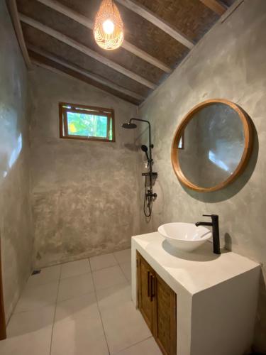 a bathroom with a sink and a mirror at Seenau House Bali in Selemadeg