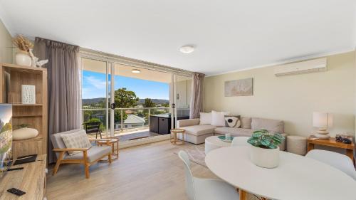 a living room with a couch and a table at Peacock Hideaway in Ettalong Beach