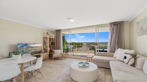 a living room with a couch and a table at Peacock Hideaway in Ettalong Beach