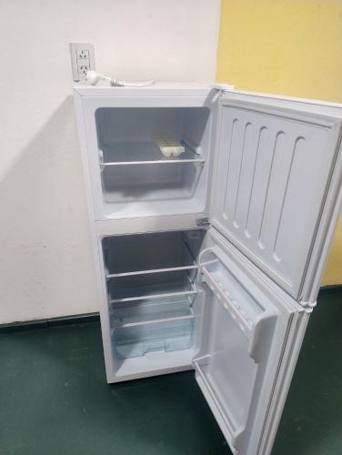 an empty refrigerator with its door open in a room at Módulos ate 3 in Punta Alta