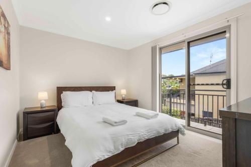 a bedroom with a bed and a large window at Manning the Waves in Kiama