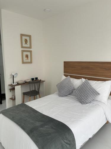 a bedroom with a white bed with a wooden headboard at Modern studio apartment Parque de la 93 in Bogotá