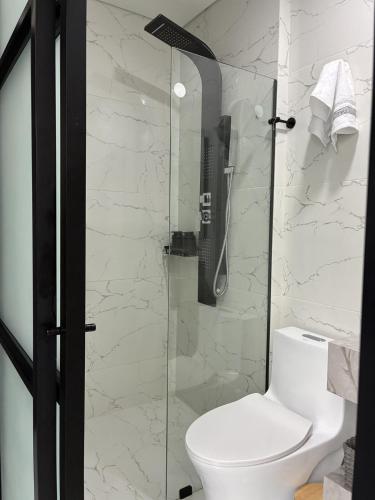 a bathroom with a toilet and a glass shower at Modern studio apartment Parque de la 93 in Bogotá