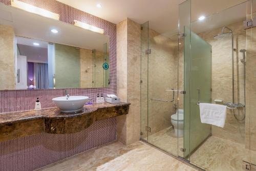 ein Badezimmer mit Waschbecken und Glasdusche in der Unterkunft TTC Hotel - Ngoc Lan in Da Lat