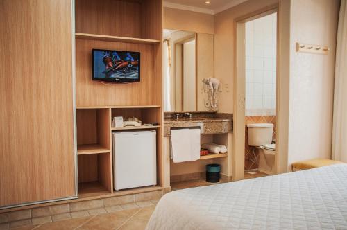 Habitación con cama y baño con lavabo. en Dunas Praia Hotel, en Torres
