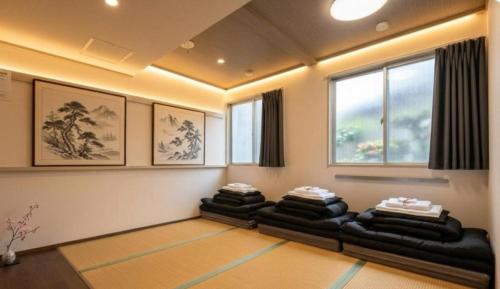 a living room with four couches in a room at 心斎橋難波関空直通Nambaminami Shin-Imamiya Ambers Hostel in Osaka